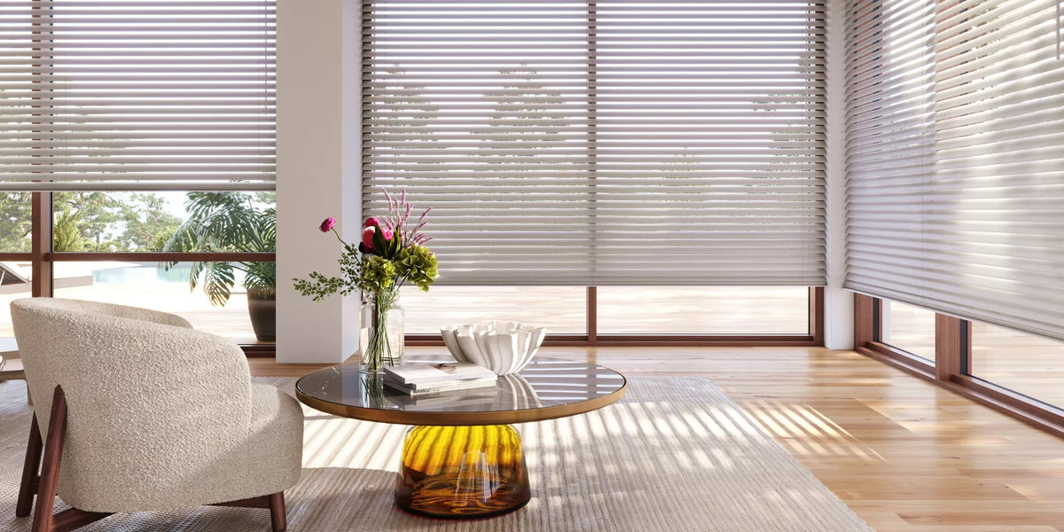 Sunlit living room with Hunter Douglas Silhouette shadings, a curved lounge chair and a round coffee table
