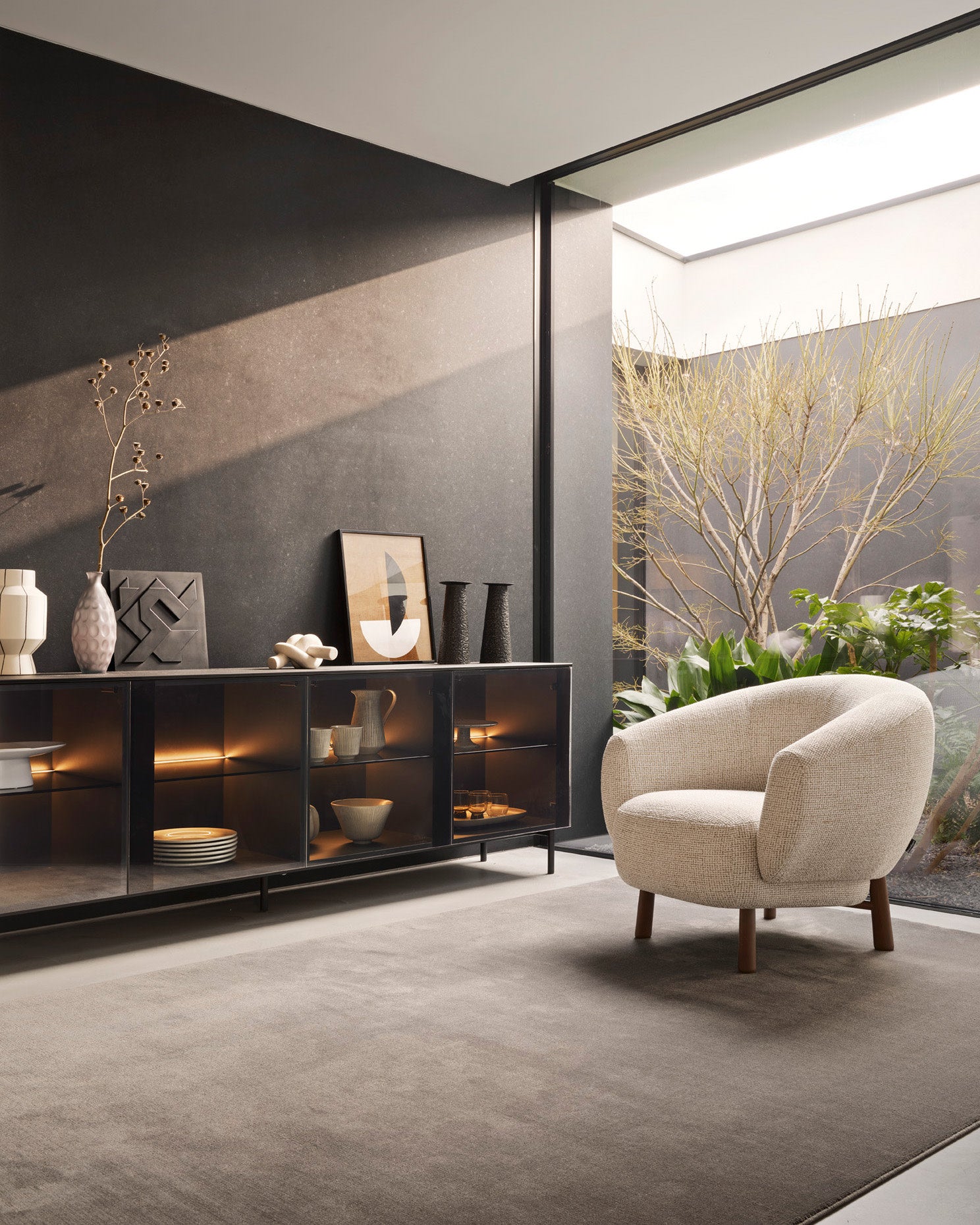 Madison rug by Calligaris with an upholstered armchair and a glass-front sideboard
