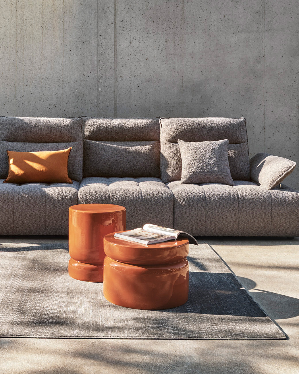 Madison rug by Calligaris under two orange side tables in front of a gray sofa