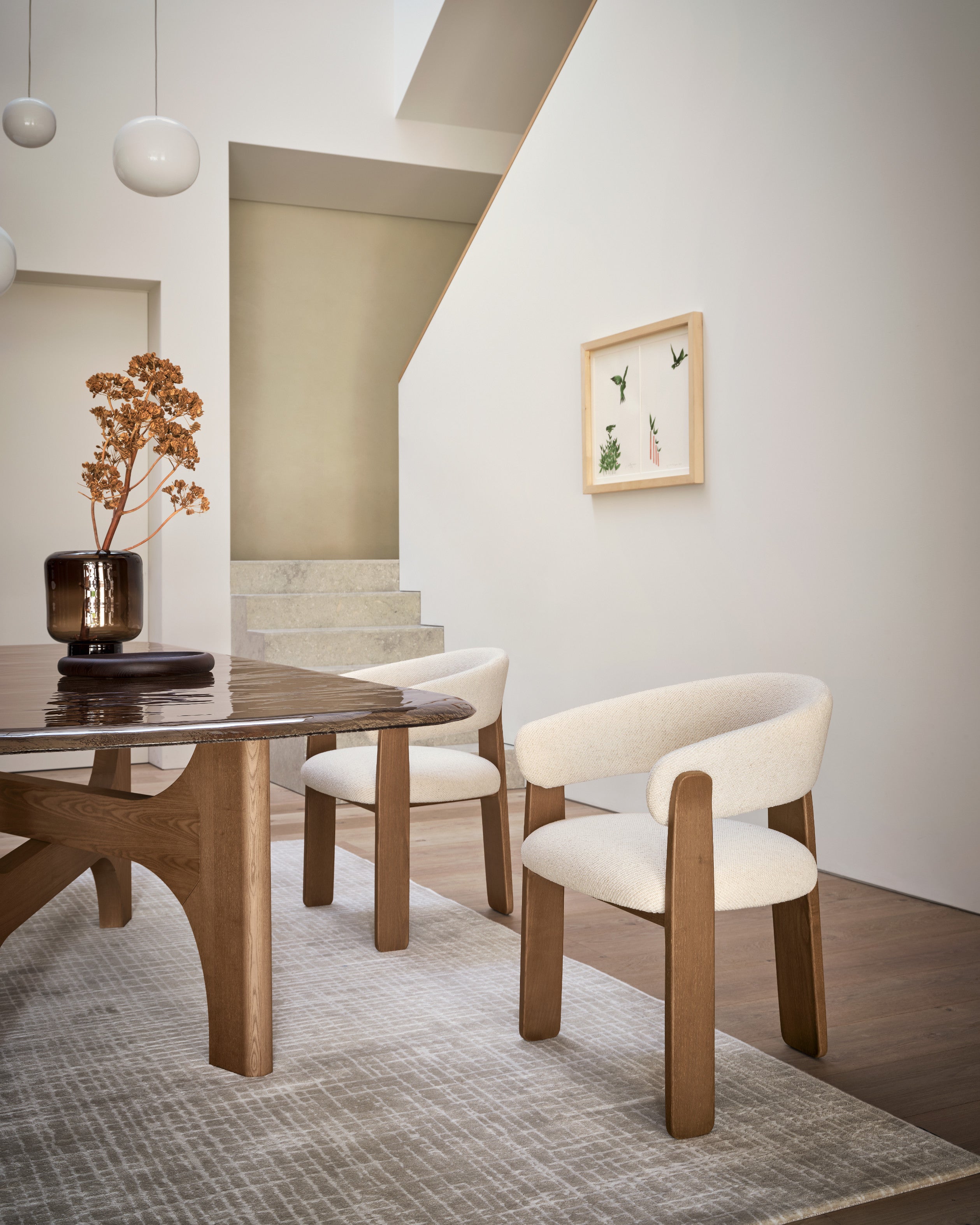 Nazca rug by Calligaris under upholstered dining chairs beside a staircase