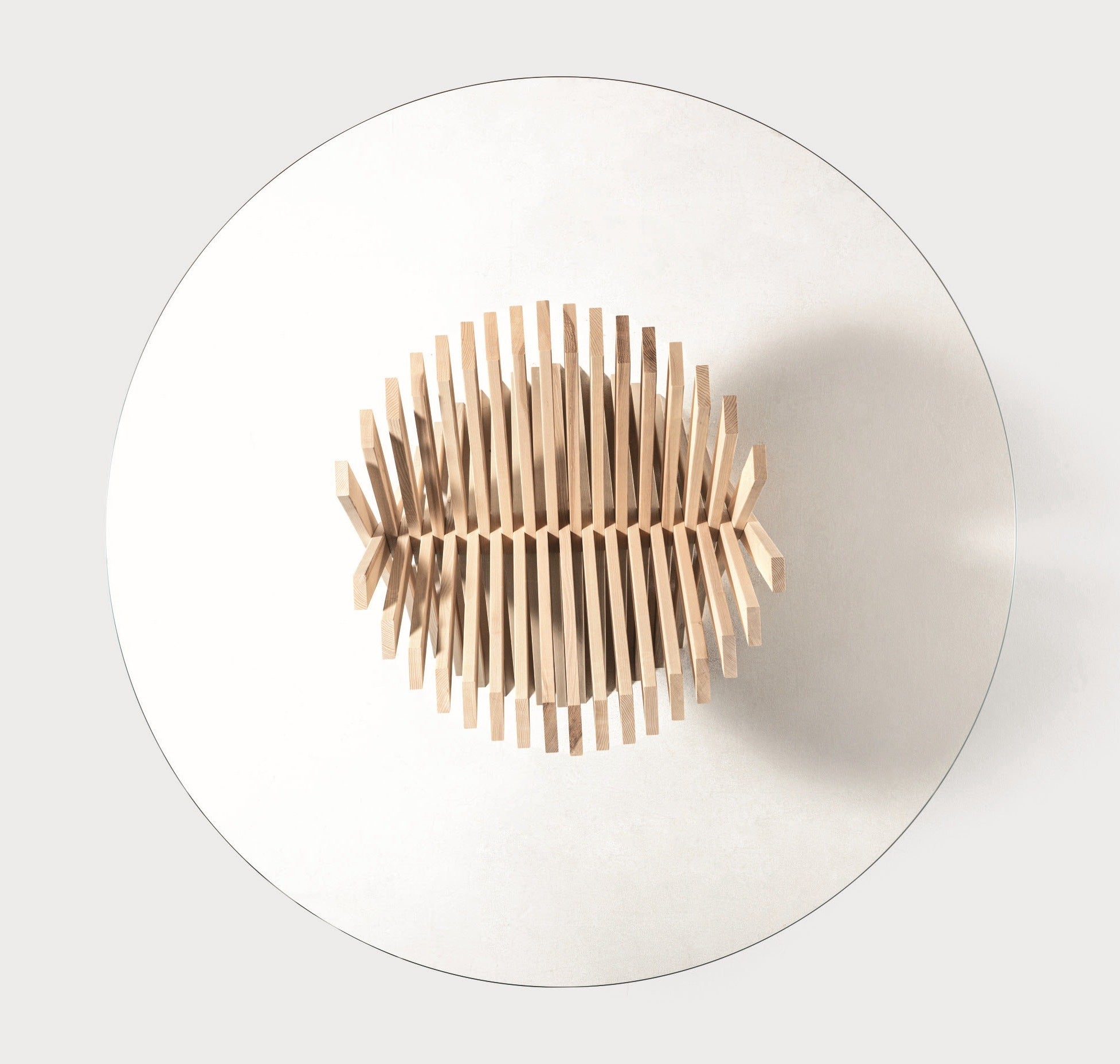 Top view of the Nest dining table by Natisa showing the ash strip base through the round clear glass top