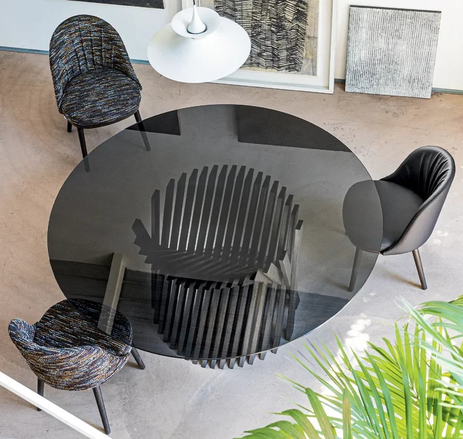 Nest dining table by Natisa with smoked glass top and dark ash base, seen from above in a dining room