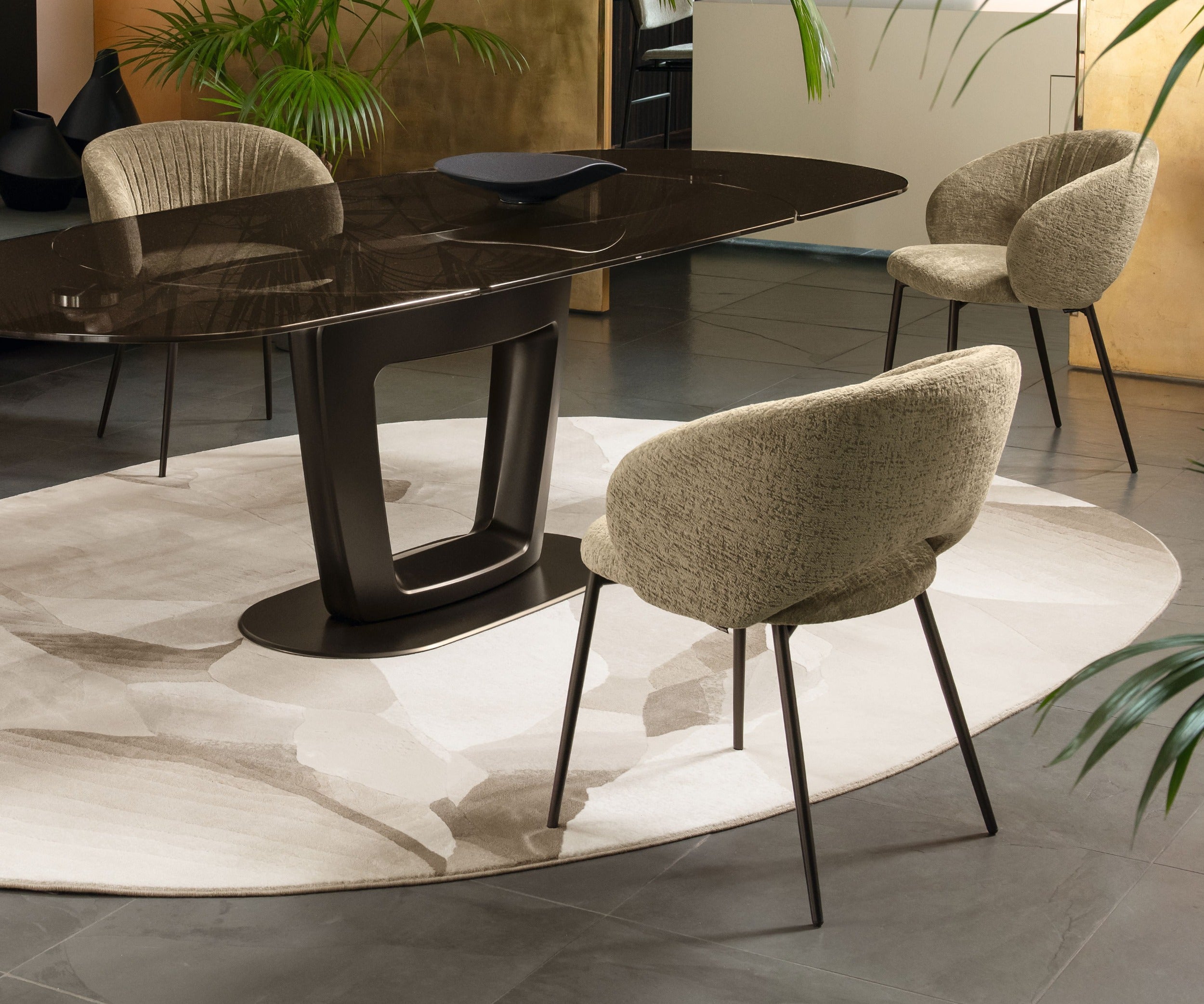 Nest rug by Calligaris under an oval dining table with upholstered chairs