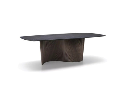 Natisa Orbit dining table with dark marble-effect barrel top and fluted wood pedestal base on white background