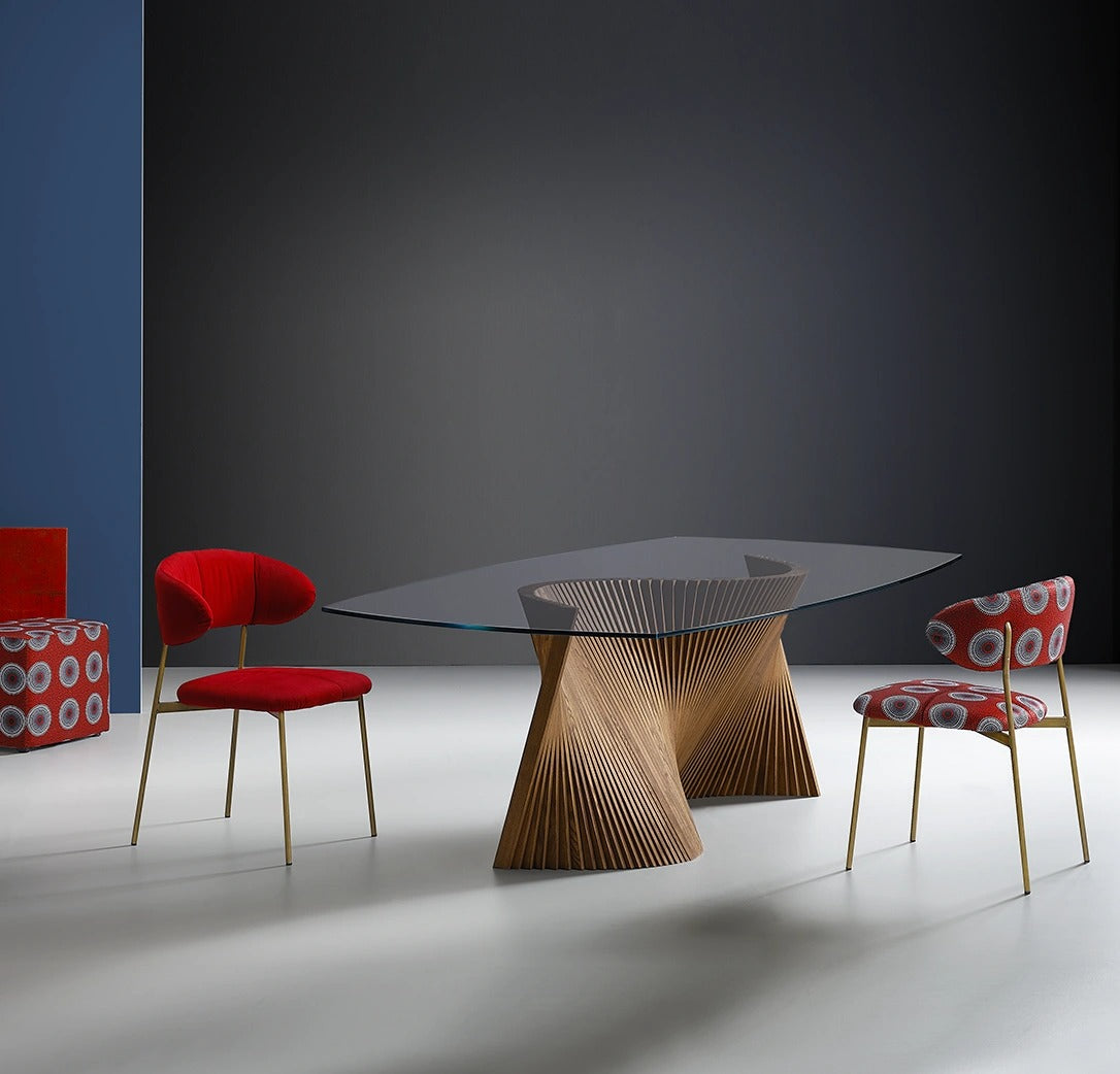 Orbit dining table with clear glass top showing the twisting natural ash base