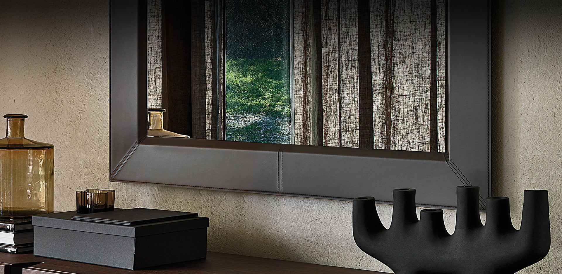 Dark brown leather Photo mirror hung horizontally above a sideboard