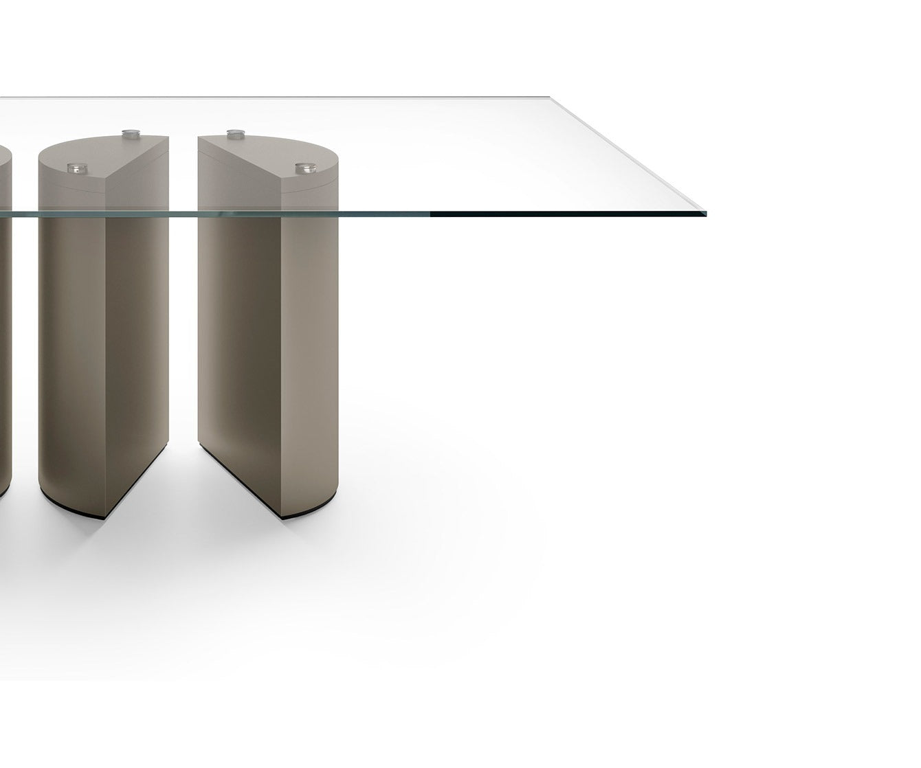 Detail of the Plai Glass Top table: extra-clear glass resting on half-moon metal legs in titanium finish