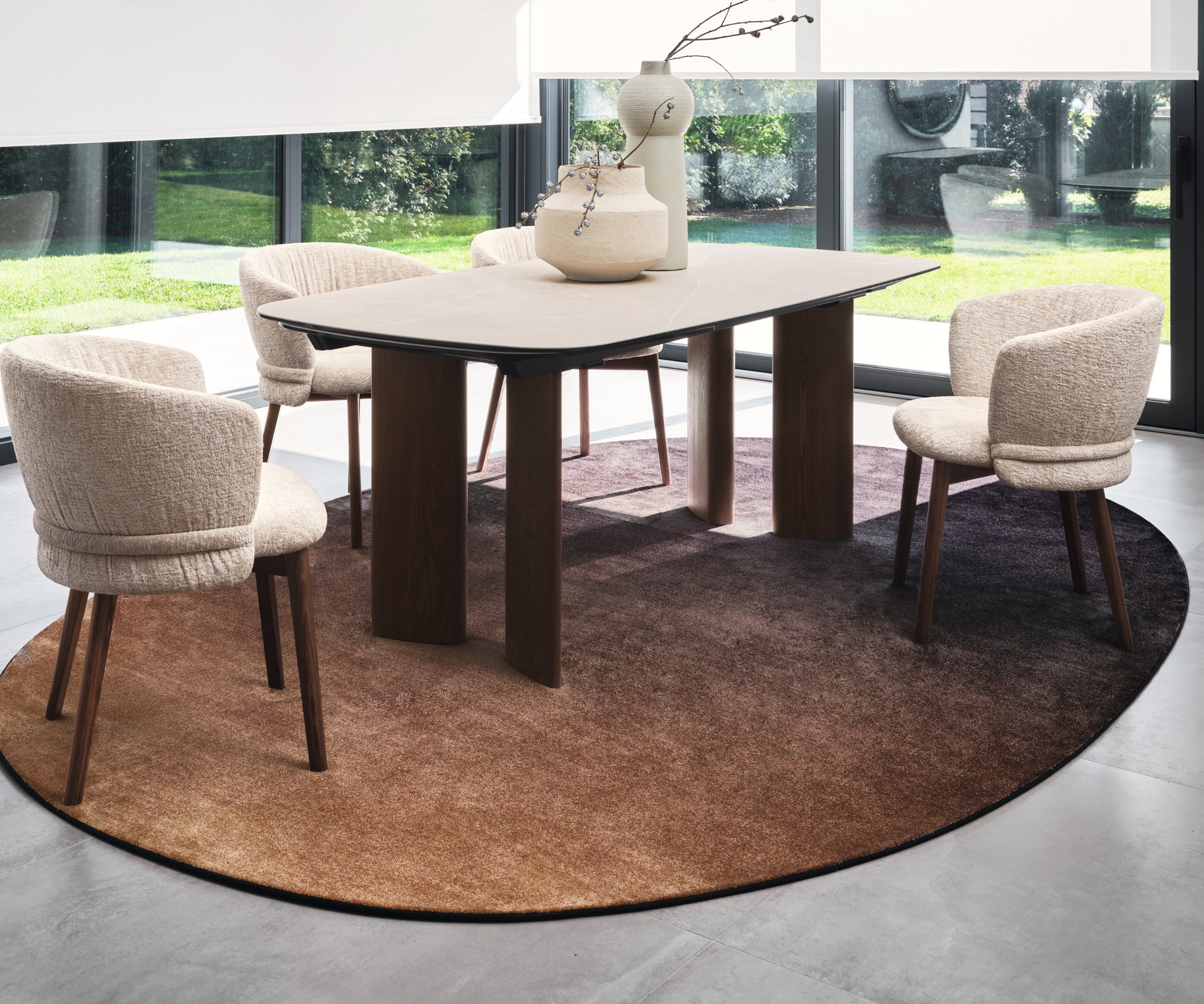 Sky oval rug by Calligaris under a dining table with four upholstered chairs