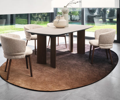 Sky oval rug by Calligaris under a dining table with four upholstered chairs