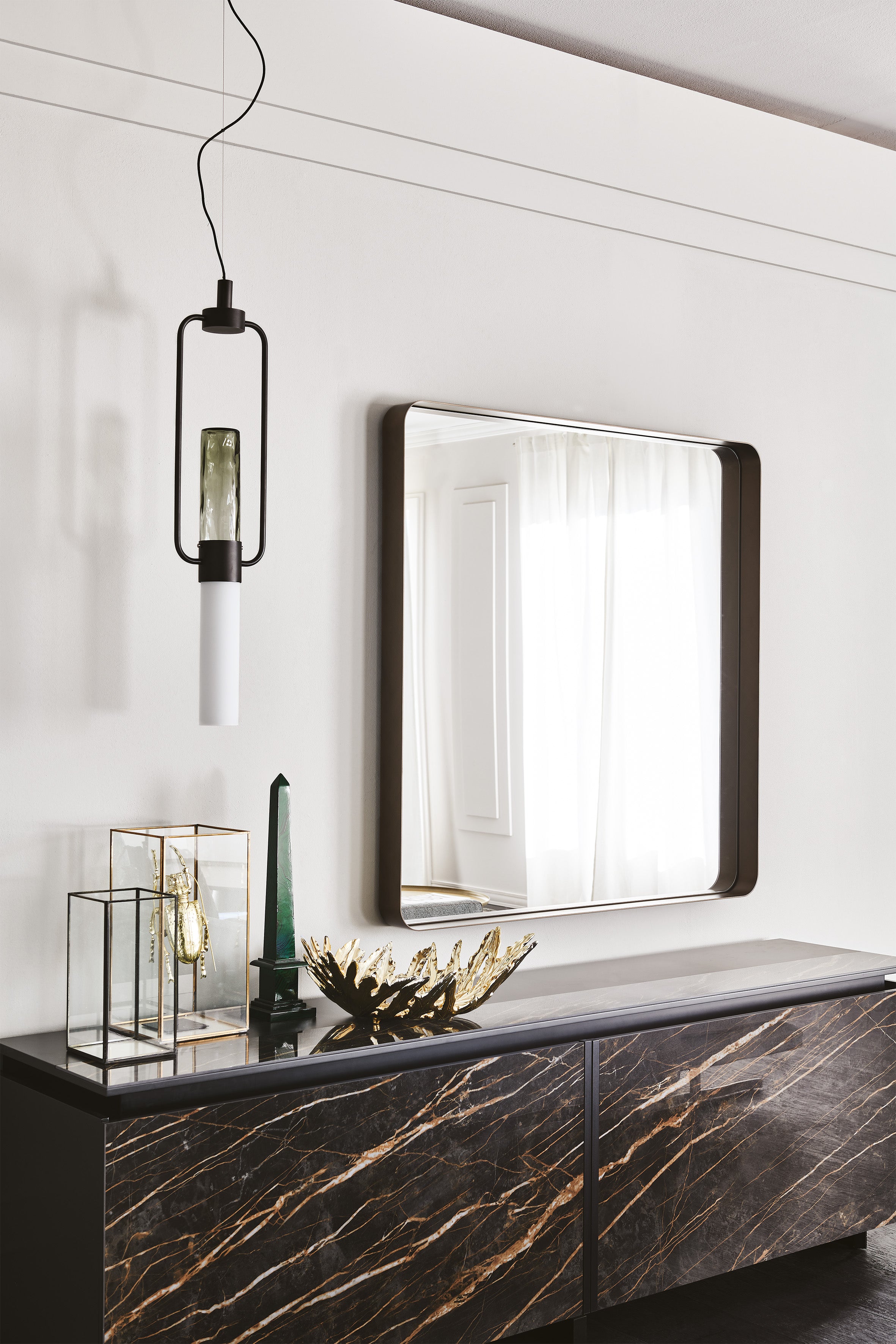 Square Wish S mirror with a dark frame on a white wall beside a pendant lamp